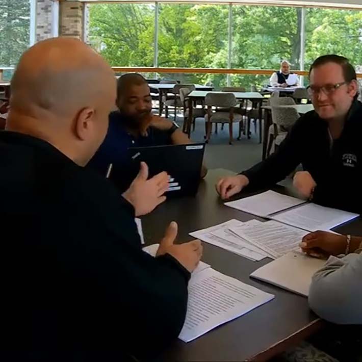 Ed.D. students discuss research at a table with cohort members.