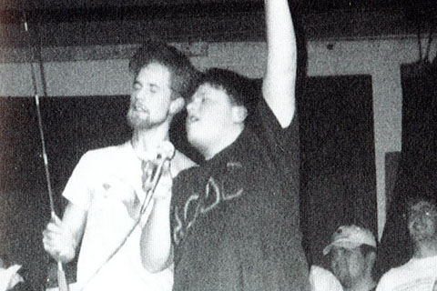 1995 student with microphone singing on stage