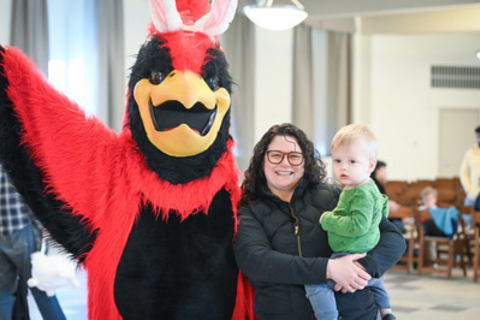Mascot wearing bunny ears and posing with a mother and child