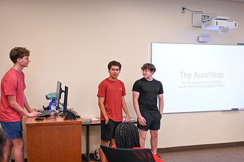 Students give a presentation at the front of the class during business camp.