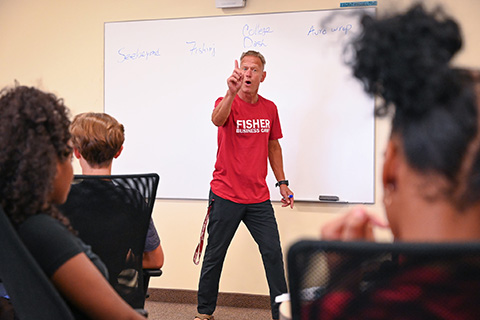 A professor gestures in front of a class during business camp.