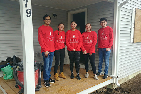 A group of Fisher volunteers work together at a Habitat for Humanity house.