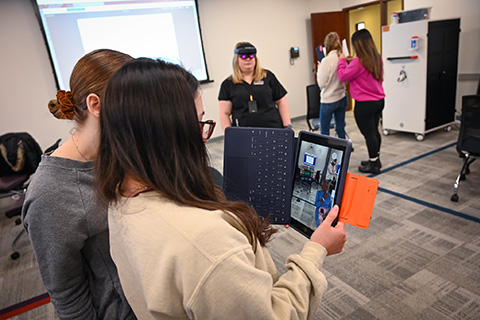 Students use an iPad as part of a course using virtual reality simulation for nursing.