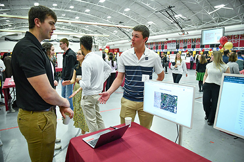 A student shares research at the Fisher Showcase.