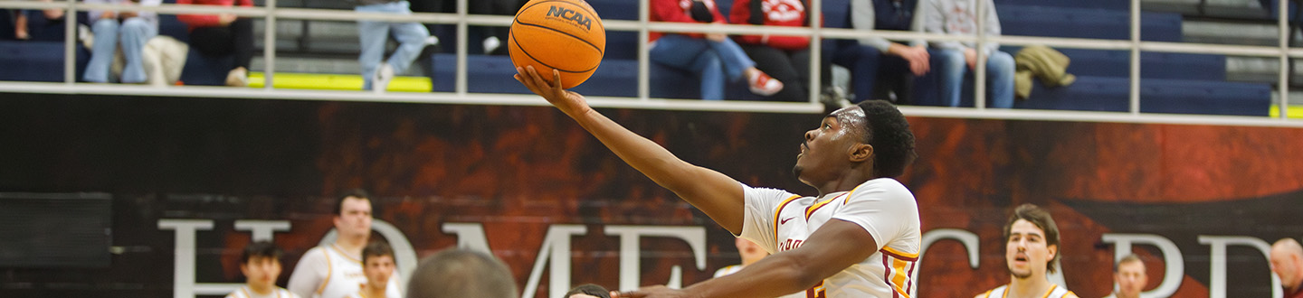 A member of the Fisher basketball team takes a shot on the hoop with the official NCAA basketball.