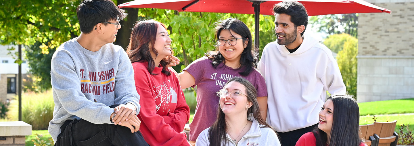 Students laughing together on campus at Fisher.