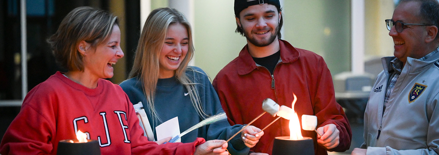 A student and her family making s'mores during Fisher's Family Weekend.