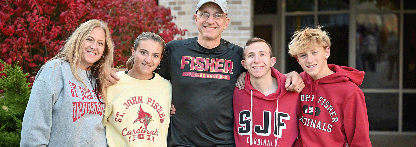 Family stands together in Fisher gear during Family Weekend.