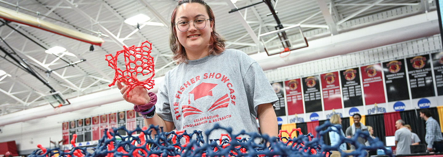 A student holds a model used in research at the Fisher Showcase.