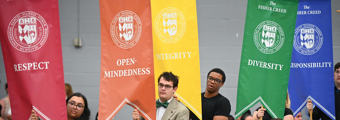 Students carry banners for the Fisher Creed to represent values of respect, open-mindedness, integrity, diversity, and responsibility.