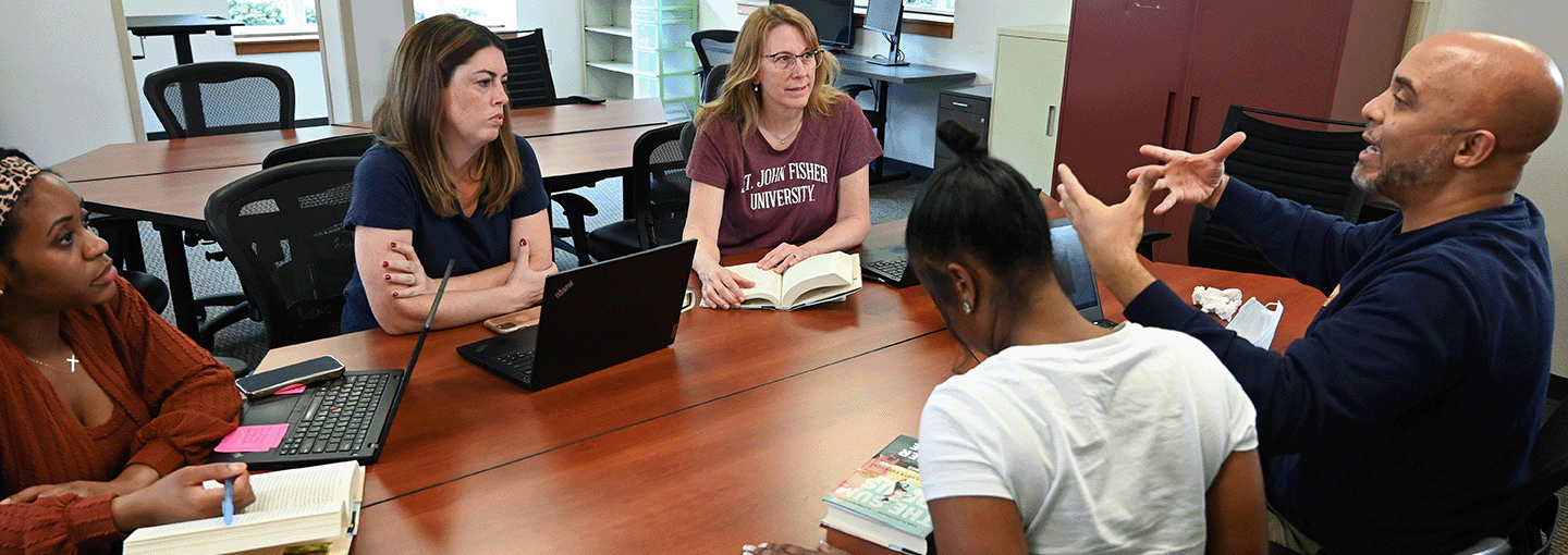 An Ed.D. student stands confidently with a large bell in the background.