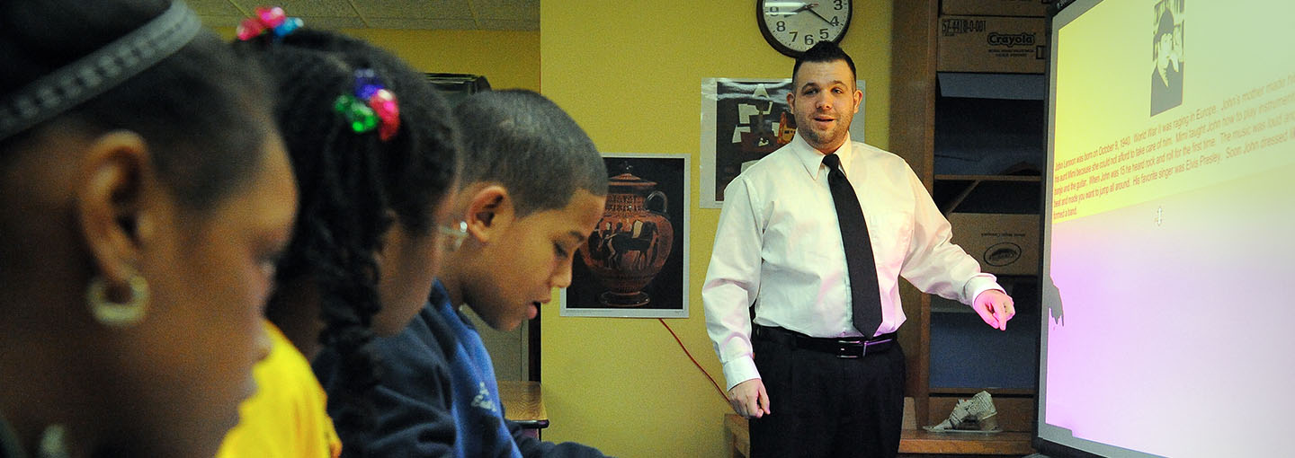 Adolescence education student teacher in front of SMART Board