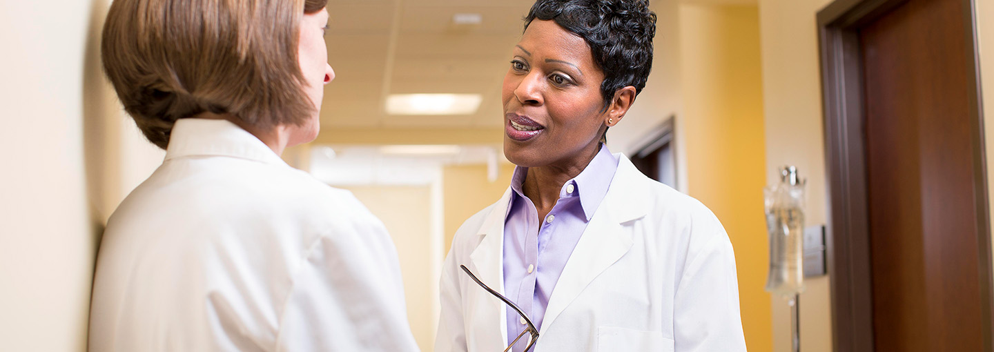 Healthcare administrators work together in the hallway of a hospital.