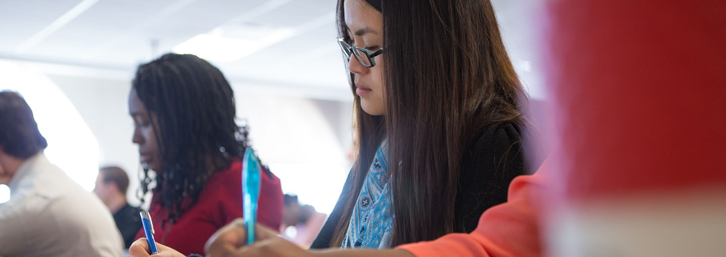 Student taking notes in class.