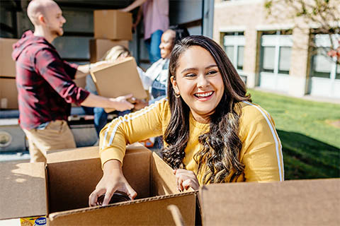 A group of students moves boxes.