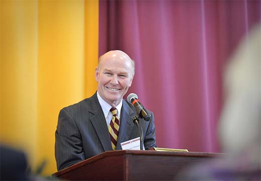 Dr. Rooney smiling at a podium.