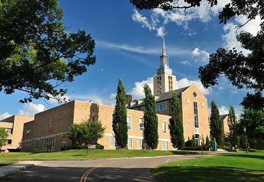 Kearney Hall steeple framed by tree branches.