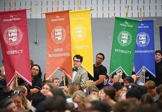 Students carry banners for the Fisher Creed to represent values of respect, open-mindedness, integrity, diversity, and responsibility.