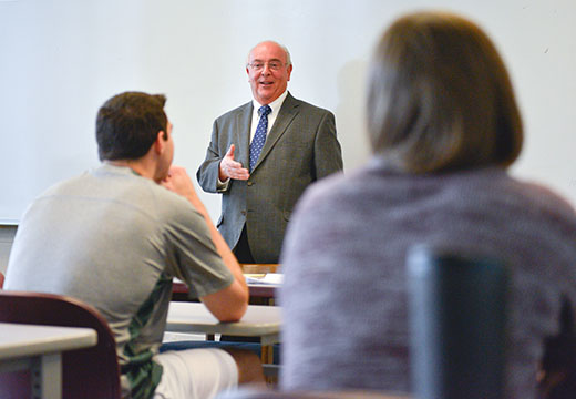 Dr. Bain teaching in front of classroom.